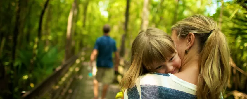 Mother and daughter walking on bridge