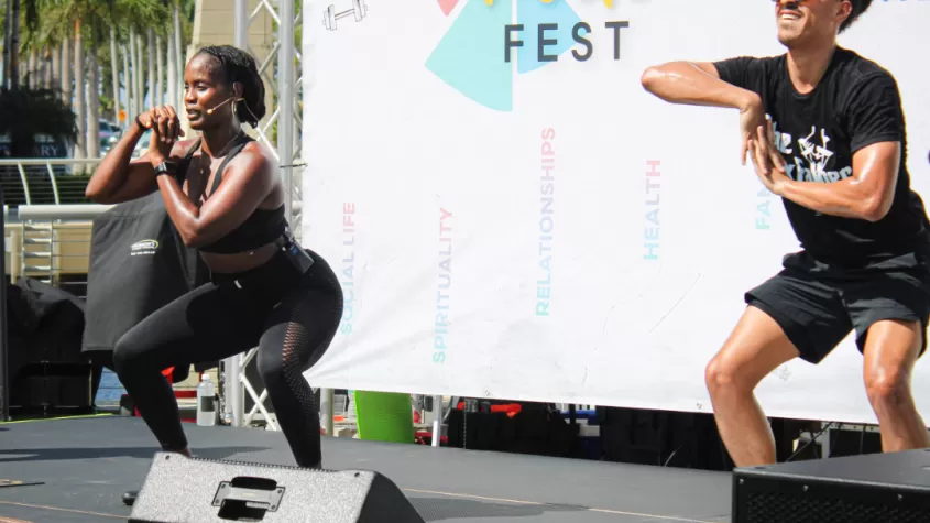 Coaches demonstrate animal flow on stage at FITMIX FEST