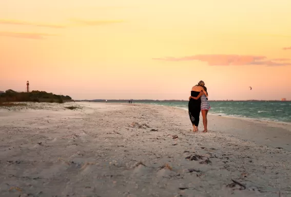 Two people hugging on a beach at sunset 